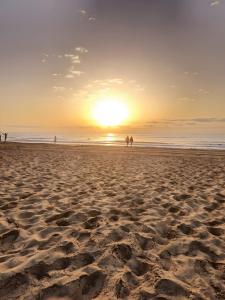 a group of people walking on the beach at sunset at Sueño in La Mata
