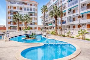 a swimming pool with a bridge in front of apartment buildings at Sueño in La Mata
