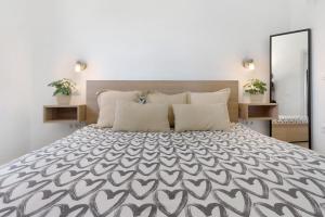 a bedroom with a large bed with a black and white bedspread at Casa Luna Kingbed and Jacuzzi in Maspalomas +19 photos