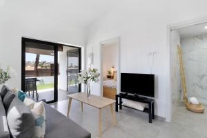 a living room with a couch and a tv at Casa Luna Kingbed and Jacuzzi in Maspalomas
