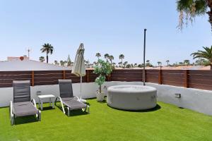 a patio with a table and chairs and an umbrella at Casa Luna Kingbed and Jacuzzi in Maspalomas