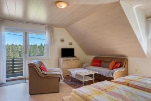 a room with a bed and a couch and a tv at Unterfalkenhof in Schramberg