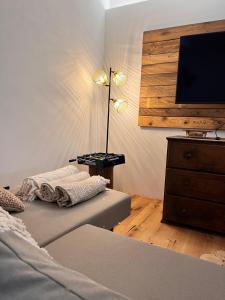 a bedroom with a bed and a flat screen tv at Casa Storica Gardola in Tignale
