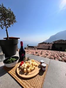 a plate of food with cheese and a bottle of wine at Casa Storica Gardola in Tignale