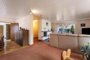 a living room with a couch and a kitchen at Haus Waldblick in Bad Berleburg