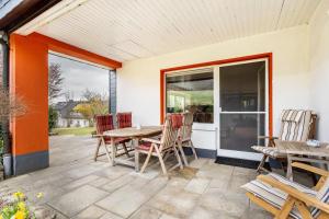 a patio with a table and chairs and a glass door at Haus Waldblick in Bad Berleburg
