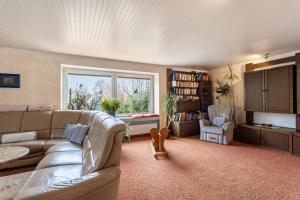 a living room with a couch and a window at Haus Waldblick in Bad Berleburg