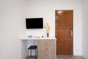 a room with a desk with a tv and a door at Apartamento nº2 - Seashel in Moncarapacho