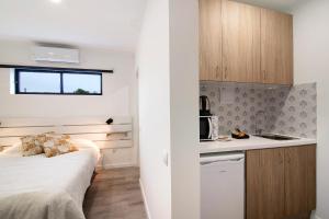 a small bedroom with a bed and a kitchen at Apartamento nº2 - Seashel in Moncarapacho
