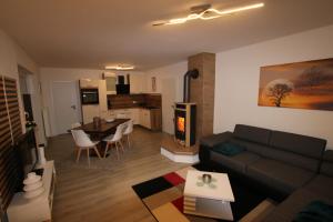 a living room with a couch and a table and a kitchen at Ferienwohnung am Bärenstein in Bärenstein