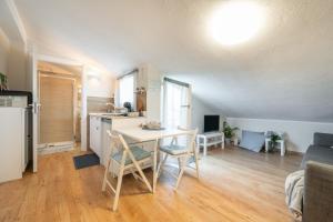 a kitchen and living room with a table and a kitchen and a couch at Al Chiaro di Luna in Decimomannu