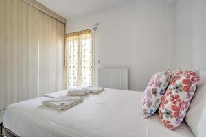 a white bedroom with a bed with towels on it at Elia home kanali in Kanali