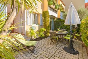 a patio with a table and an umbrella and chairs at Apartment Avenue Des Terrasses in Cassis