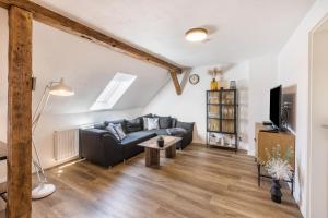 a living room with a couch and a tv at Eichendorff Loft in Nordhausen