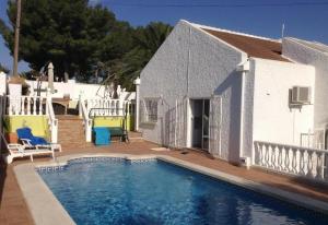 a swimming pool in front of a white house at Villa with private pool - near golf in San Miguel de Salinas