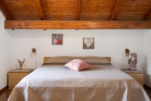 a bedroom with a bed with a pink pillow on it at Residence Bonetti in Rabbi