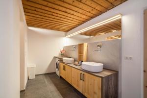 a bathroom with two sinks and two mirrors at Unterlanpacher Historic Refugium in Laces +29 photos