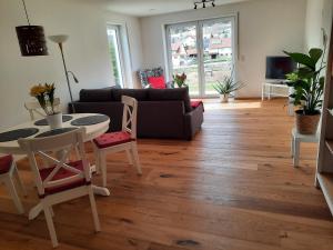 a living room with a couch and a table and chairs at Ferienwohnung Im Eyachtal in Albstadt