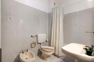 a white bathroom with a toilet and a sink at Beachfront Apartment T2 in Quarteira +18 photos