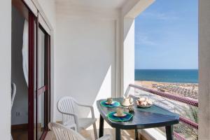 a balcony with a table and a view of the ocean at Beachfront Apartment T2 in Quarteira