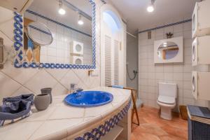 a bathroom with a blue sink and a toilet at Beachfront Apartment Port de Soller in Sóller