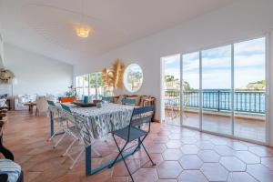 a dining room with a table and views of the ocean at Beachfront Apartment Port de Soller in Sóller
