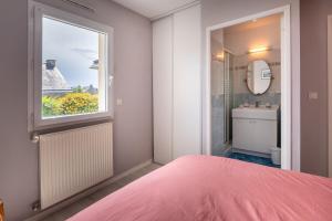 a bedroom with a pink bed and a window at Ty Gwen in Ploeren