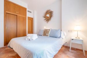 a bedroom with a bed with towels on it at Beachfront Apartment Port de Soller in Sóller