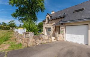 a house with a garage and a stone wall at Ty Gwen in Ploeren