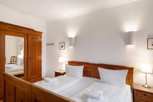 a bedroom with two beds with white sheets and a mirror at Gut Rattelvitz - Parterre Ost in Gingst