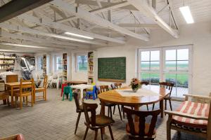 a classroom with tables and chairs and a chalkboard at Gut Rattelvitz - Parterre Ost in Gingst