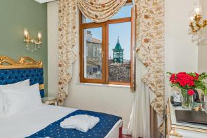 Schlafzimmer mit einem Bett und einem Fenster in der Unterkunft Galatower Hotel in Istanbul