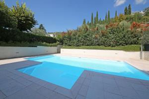 a swimming pool with blue water in a yard at Villa Bornico Marisa in Toscolano Maderno