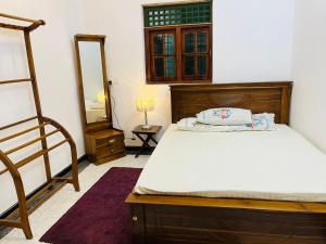 a bedroom with a bed and a mirror at Hamdan Villa in Dharga Town