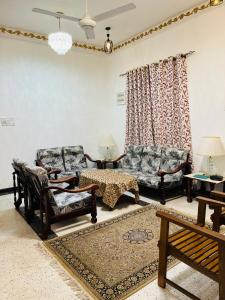 a living room with a couch and chairs and a table at Hamdan Villa in Dharga Town