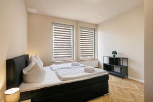 a bedroom with a bed with white sheets and a window at Hotel zur Panke Wohnung 5 in Kolonie Röntgental