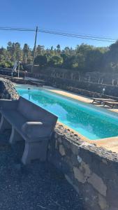 a bench sitting next to a swimming pool at Apartamentos Los Aljibes in Las Tricias