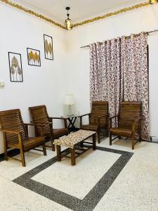 a living room with rocking chairs and a table at Hamdan Villa in Dharga Town