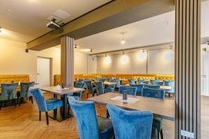 a dining room with tables and blue chairs at Hotel zur Panke Wohnung 5 in Kolonie Röntgental