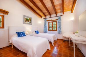 a bedroom with two beds and a table at Can Seguinot D'alt in Pollença +27 photos