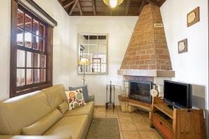 a living room with a couch and a fireplace at Apartamentos Los Aljibes in Las Tricias