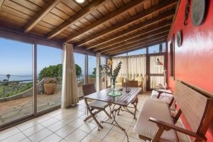 a living room with a table and chairs and a view of the ocean at Apartamentos Los Aljibes in Las Tricias