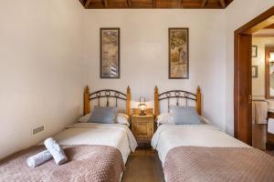 a bedroom with two beds and a night stand with a lamp at Apartamentos Los Aljibes in Las Tricias +49 photos