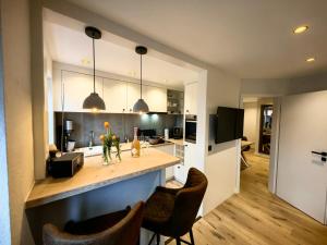a kitchen with a counter and some chairs in a room at nord-ostseeglück in Ladelund