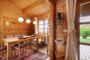 a dining room in a log cabin with a table and chairs at Hüssli Numero 1 in Hayingen