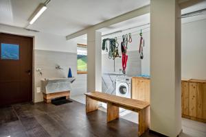 a laundry room with a washing machine and a bench at La Chiasa in Rabbi +91 photos