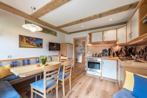 a kitchen and living room with a table and chairs at Bergblick App Lärche in Villnoss +23 photos