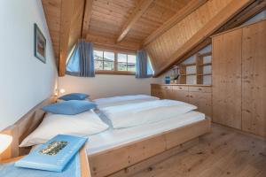 a large bed in a room with wooden walls at Bergblick App Lärche in Villnoss