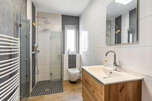 a bathroom with a sink and a shower and a toilet at Das Atelier in Ihlow +34 photos