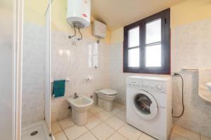 a bathroom with a washing machine and a toilet at Via Mazzini 87 in Calasetta +18 photos